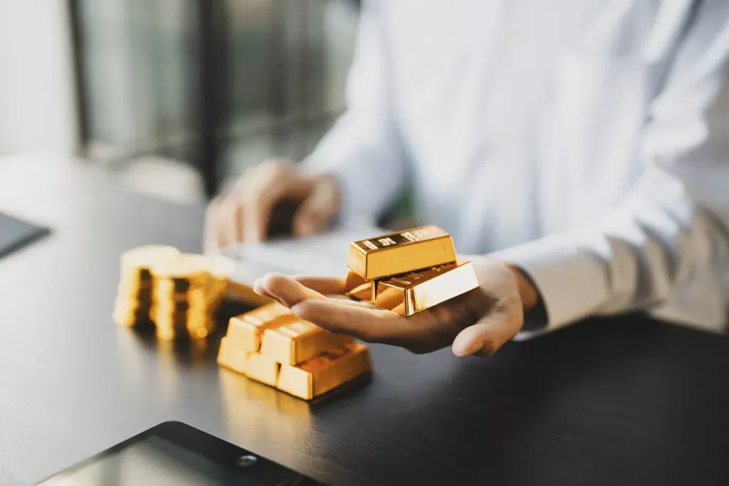  Inwestor trzyma w dłoni sztabki złota